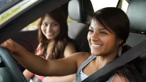 two hispanic women in car smiling