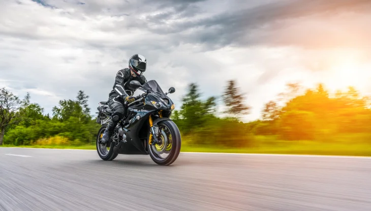 Person riding motorcycle on road.