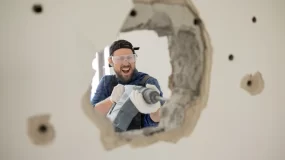 Crazy man makes a hole in the wall.