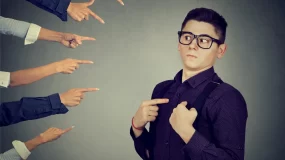 Many hands pointing fingers to a person
