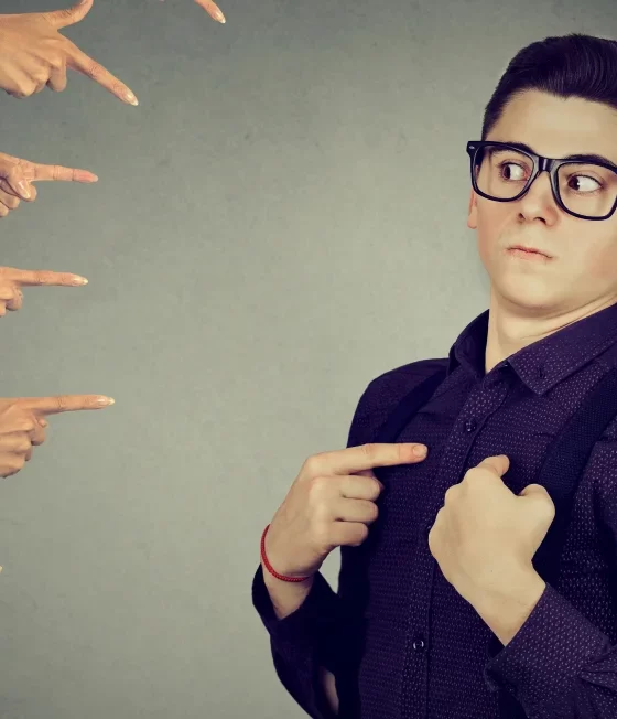 Many hands pointing fingers to a person