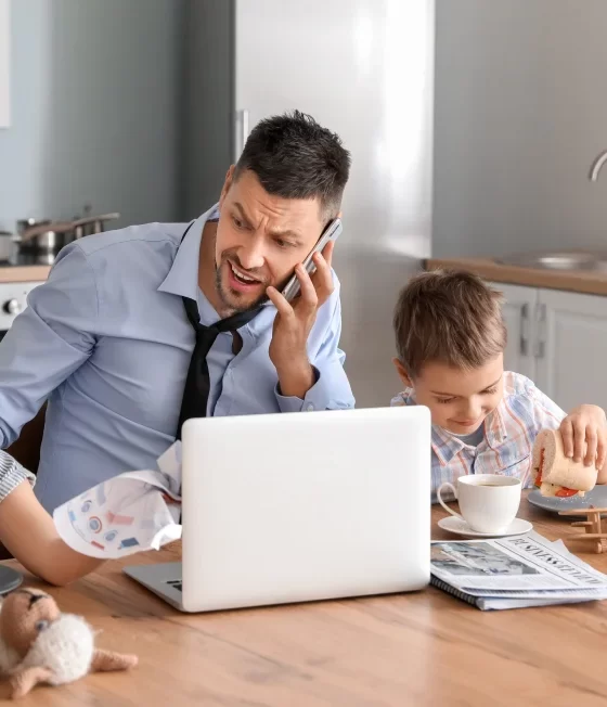 Father at home working with children around.
