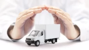 hands protecting commercial truck to symbolize insurance coverage