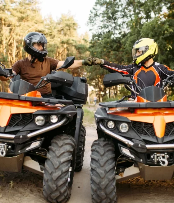 ATV riders fist bump on a trail in Georgia.