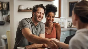Young bi-racial couple shakes hands with insurance agent for home insurance in macon, ga.