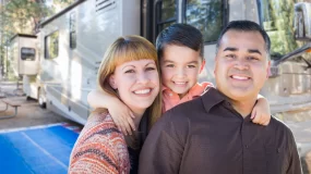 Smiling family in front of their RV.