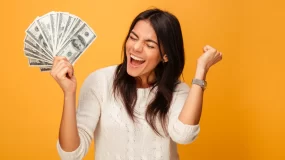 Young woman with fistful of money and excited