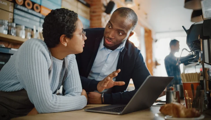 Business leader meeting with employee over computer.