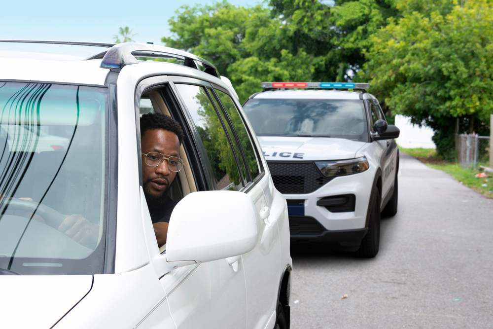 young man getting pulled over by cop while driving