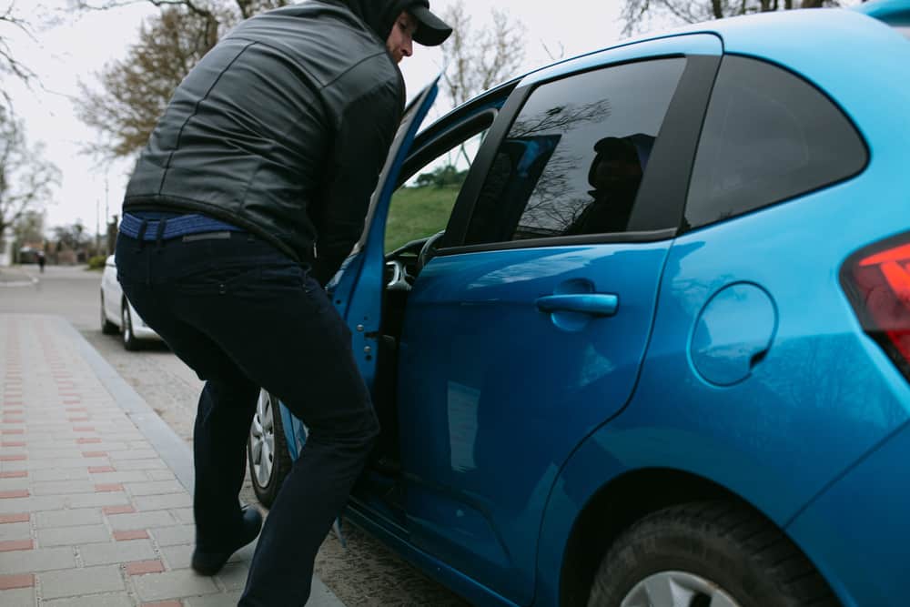 Thief stealing blue car